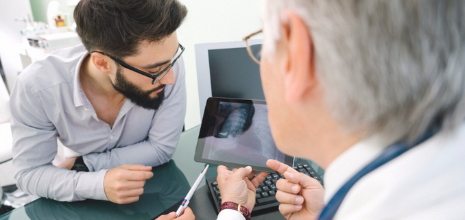 Photo of Doctor and Patient Looking at an X-Ray