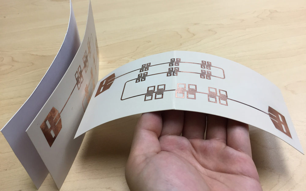 Printed thin, flexible LiveTag tags in comparison with a piece of photo paper