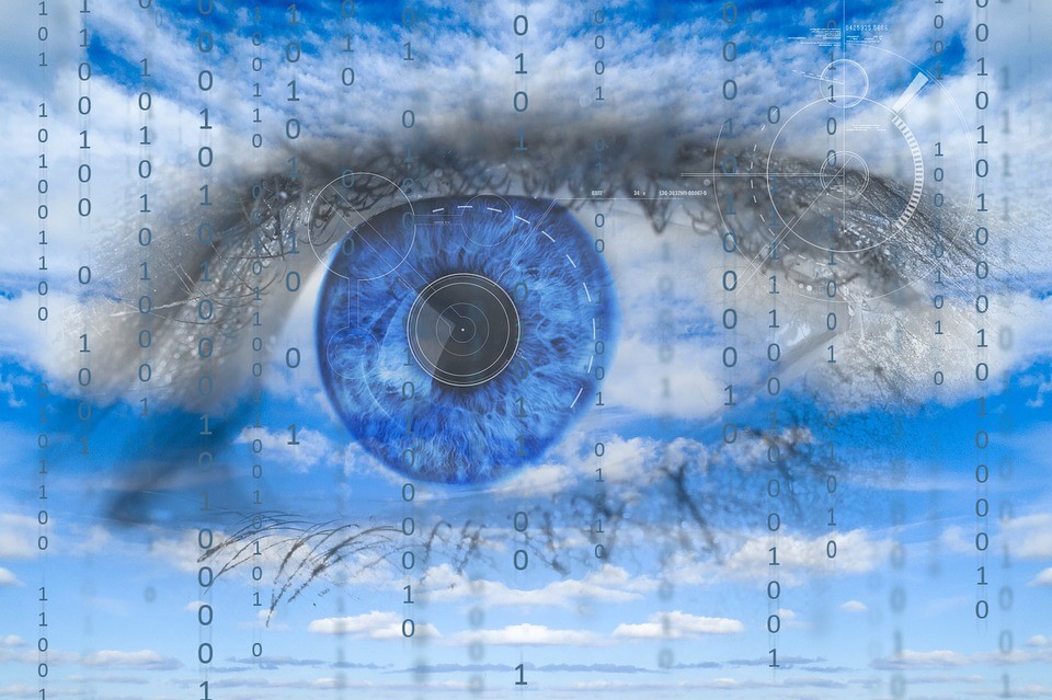 A giant blue eye with lines of binary code written over it