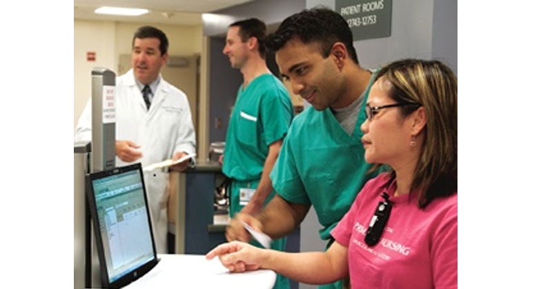 Two medical professionals look at a computer screen in a hospital