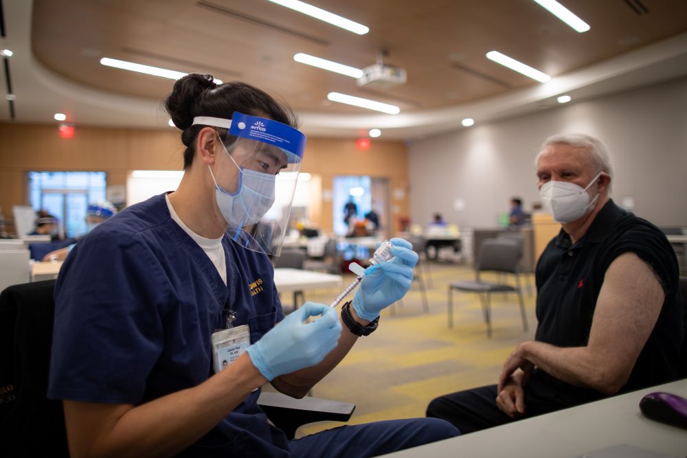 Sergio Aguilar-Gaxiola, Director, UC Davis Center for Reducing Health Disparities, gets his second Moderna COVID-19 vaccine shot. Nurse is Jason Yee.