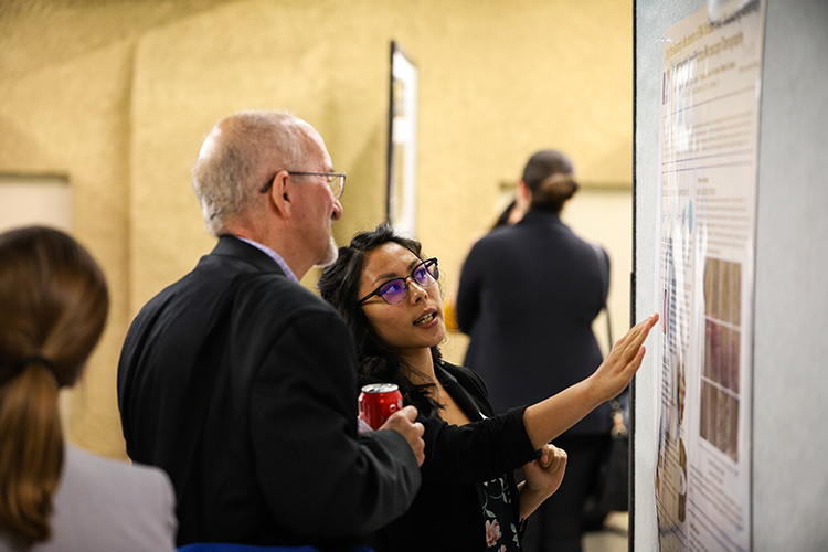 Two people looking at a whiteboard, talking