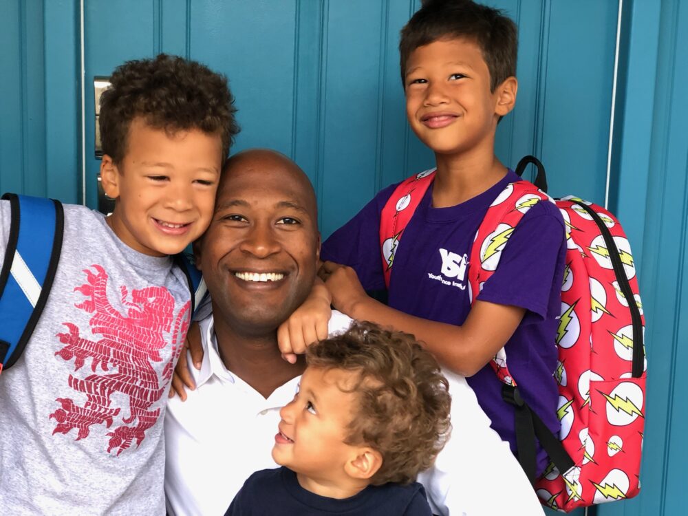 Van Williams, UC CIO, being hugged by his three children