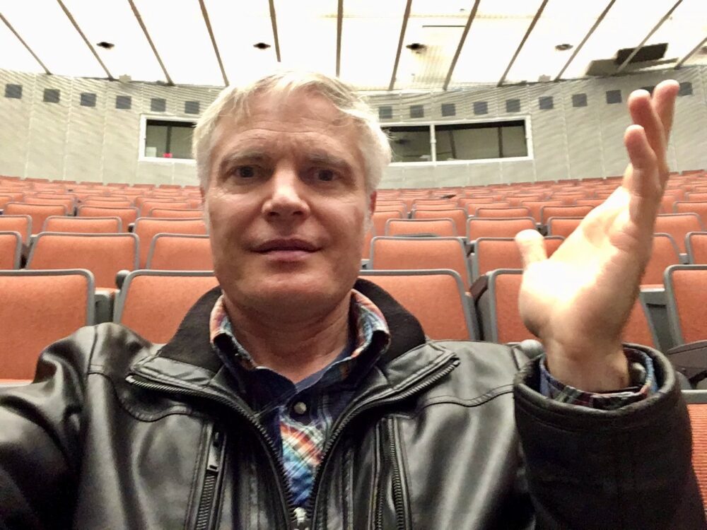 Ezra Daly sits in an empty lecture hall,