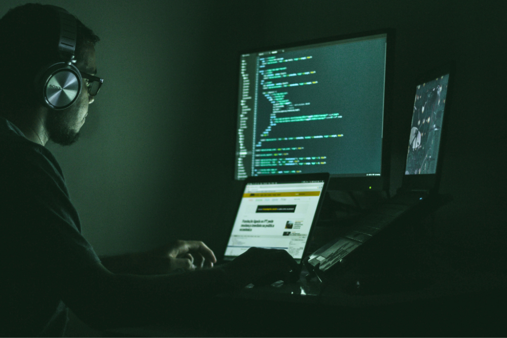 Cybersecurity Awareness Month header - man looking at computer screens