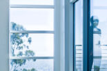 Blue photo of a window with a shadow of a person on the right.